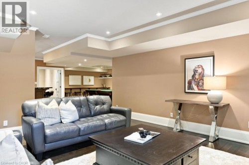 Recessed lighting, crown molding, wood-finish flooring, and a built-in wet bar with seating - 253 Rossmore Boulevard, Burlington, ON - Indoor Photo Showing Living Room