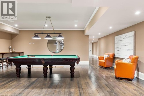Spacious recreation room featuring wood-finish flooring, recessed lighting, and a suspended billiard light fixture - 253 Rossmore Boulevard, Burlington, ON - Indoor Photo Showing Other Room