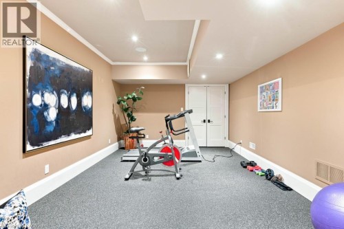 Recessed ceiling lighting, textured wall-to-wall carpeting, white trim, and solid double doors - 253 Rossmore Boulevard, Burlington, ON - Indoor Photo Showing Gym Room