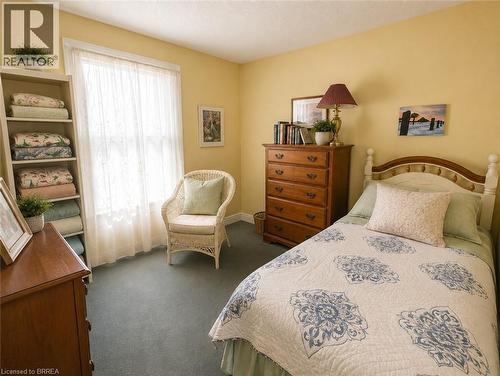 Soft carpeting, light-coloured walls, and a window with sheer curtains create a bright and comfortable space. - 49 Palmerston Avenue, Brantford, ON - Indoor Photo Showing Bedroom