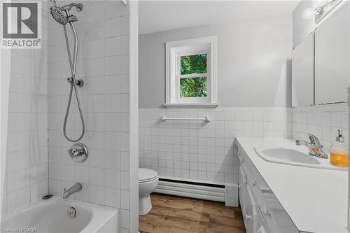 Bathroom featuring a tub/shower combination with a hand-held shower head, a window, and a vanity with an integrated sink - 41 Mill Street, Mississauga, ON - Indoor Photo Showing Bathroom
