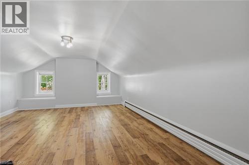 Spacious room featuring wood-finish flooring, two windows with sills, a track light fixture, and baseboard heating - 41 Mill Street, Mississauga, ON - Indoor Photo Showing Other Room