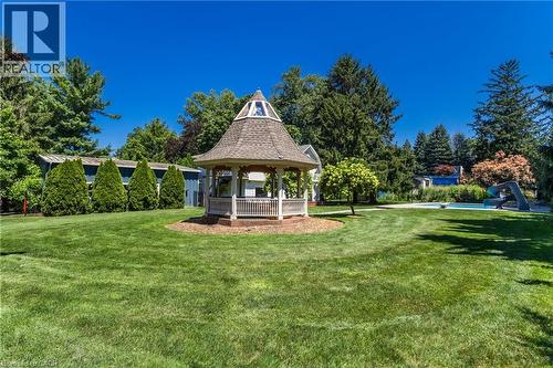 Expansive lawn featuring a gazebo with a shingled roof, mature trees, and a swimming pool - 21 Kerman Avenue, Grimsby, ON 