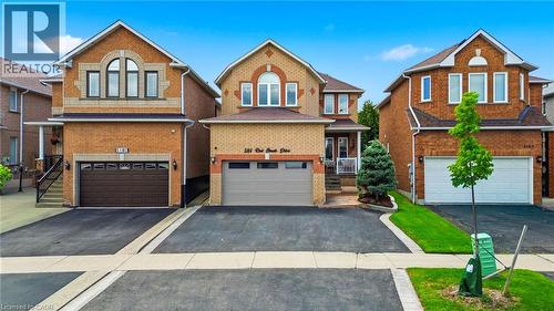Brick exterior featuring a gabled roofline, arched window detail, and a two-car garage - 5184 Red Brush Drive, Mississauga, ON - Outdoor With Facade