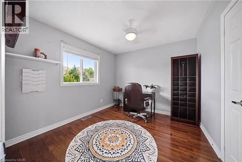 Light grey interior walls with crown molding, a white window frame, wood-finish flooring, and a ceiling-mounted light fixture - 5184 Red Brush Drive, Mississauga, ON - Indoor Photo Showing Other Room