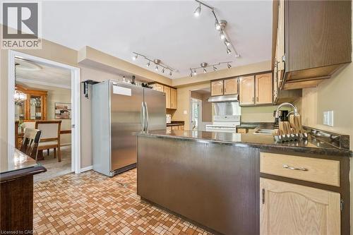 Kitchen featuring a stainless steel refrigerator, dark countertops, and light wood cabinetry with dark upper cabinets - 119 Sandy Ridge Place, Waterloo, ON - Indoor Photo Showing Kitchen With Double Sink