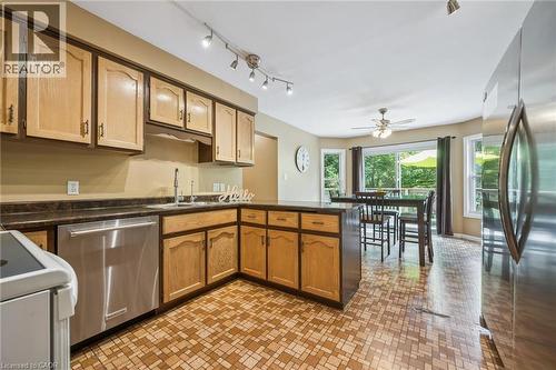 Kitchen with light wood-finish cabinetry, dark countertops, and stainless steel appliances - 119 Sandy Ridge Place, Waterloo, ON - Indoor Photo Showing Kitchen