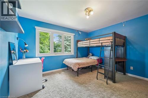 Wall-mounted shelving with a white desk, large window with white trim, track lighting fixture, and carpeted flooring - 119 Sandy Ridge Place, Waterloo, ON - Indoor Photo Showing Bedroom