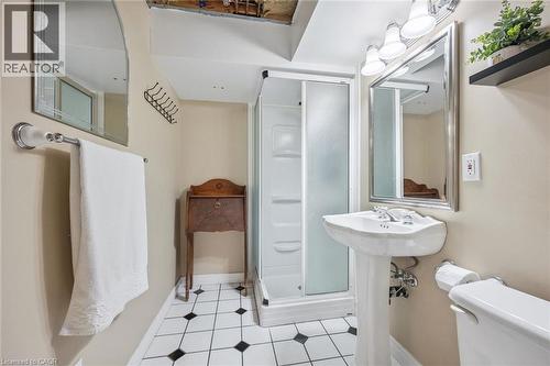 Compact bathroom featuring a shower enclosure, pedestal sink, and black and white flooring - 119 Sandy Ridge Place, Waterloo, ON - Indoor Photo Showing Bathroom