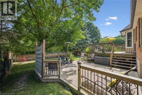 Multi-level wood deck with wood railings, brick exterior, bay window, and manicured lawn - 119 Sandy Ridge Place, Waterloo, ON - Outdoor With Deck Patio Veranda