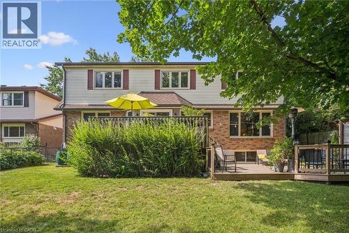 Expansive backyard featuring a manicured lawn, two-story home with brick and siding exterior, and a multi-level wood deck - 119 Sandy Ridge Place, Waterloo, ON - Outdoor