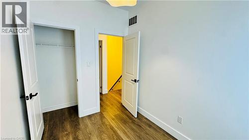 Wood-finish flooring with white baseboards and trim - 1159 Lloyd Landing, Milton, ON - Indoor Photo Showing Other Room