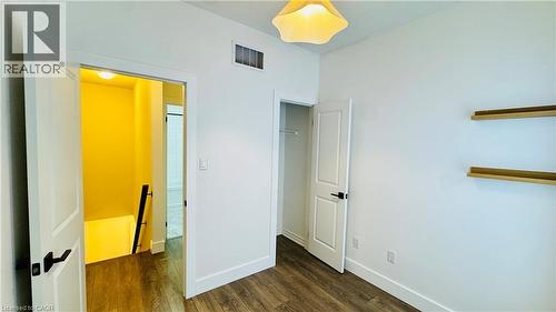 White walls with wood-finish flooring, accent shelving, and a built-in closet - 1159 Lloyd Landing, Milton, ON - Indoor Photo Showing Other Room