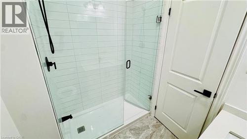 Frameless glass shower enclosure with matte black fixtures, white subway tile surround, and a white shower pan - 1159 Lloyd Landing, Milton, ON - Indoor Photo Showing Bathroom