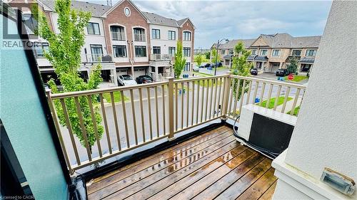 Private balcony featuring wood-finish decking and neutral-toned railing - 1159 Lloyd Landing, Milton, ON - Outdoor