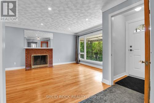 Original hardwood floors with large front window - 1227 Portland Avenue, Ottawa, ON - Indoor Photo Showing Living Room With Fireplace