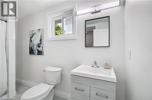 Modern bathroom featuring a single vanity with wood-grain cabinetry, integrated sink, and chrome faucet - 10 Comet Avenue Unit# #1 (Main), Hamilton, ON - Indoor Photo Showing Bathroom