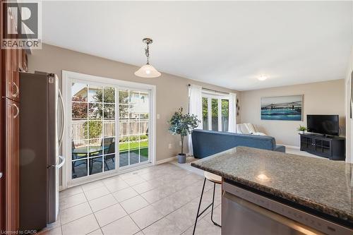 Tiled flooring, sliding glass door with backyard patio access, recessed lighting, bay window, and a built-in kitchen island with stone-finish countertop - 171 Chase Crescent, Cambridge, ON - Indoor Photo Showing Kitchen