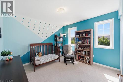 Carpeted room featuring multiple windows, a ceiling-mounted light fixture, and built-in shelving - 171 Chase Crescent, Cambridge, ON - Indoor Photo Showing Bedroom