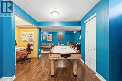 Wood-finish flooring throughout, featuring a recessed ceiling light, white bi-fold closet doors, and painted accent walls - 171 Chase Crescent, Cambridge, ON - Indoor Photo Showing Other Room