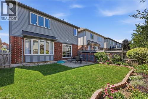 Expansive backyard featuring a manicured lawn, paver patio, established garden beds, and privacy fencing - 171 Chase Crescent, Cambridge, ON - Outdoor With Exterior