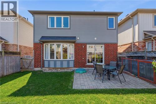 Expansive backyard featuring a manicured lawn, paver patio, and red brick lower exterior - 171 Chase Crescent, Cambridge, ON - Outdoor With Exterior