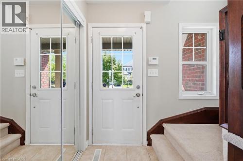 Entryway with tile flooring, a white paneled door with divided lites, a mirrored closet door, and a white framed window - 171 Chase Crescent, Cambridge, ON - Indoor Photo Showing Other Room