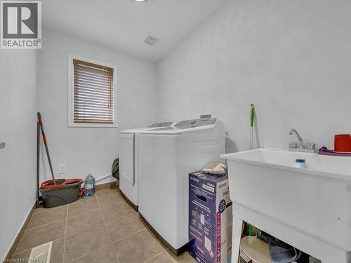 Utility room featuring tiled flooring and a window with wood-finish blinds - 227 Baldwin Drive Unit# Main, Cambridge, ON - Indoor Photo Showing Laundry Room