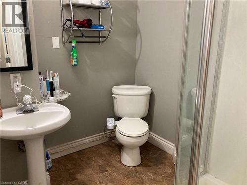 Pedestal sink with a wall-mounted mirror, ceramic toilet, and a glass-enclosed shower - 720 Brookmill Place, Waterloo, ON - Indoor Photo Showing Bathroom
