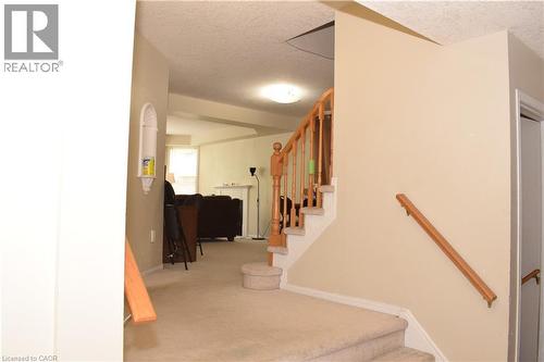 Carpeted staircase with wood handrails and balusters - 720 Brookmill Place, Waterloo, ON - Indoor Photo Showing Other Room