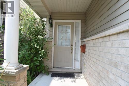 Front entryway featuring a decorative glass door, sidelight, and an exterior wall light fixture - 720 Brookmill Place, Waterloo, ON - Outdoor With Exterior