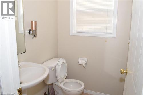 White ceramic toilet, pedestal sink, and window with horizontal blinds - 720 Brookmill Place, Waterloo, ON - Indoor Photo Showing Bathroom