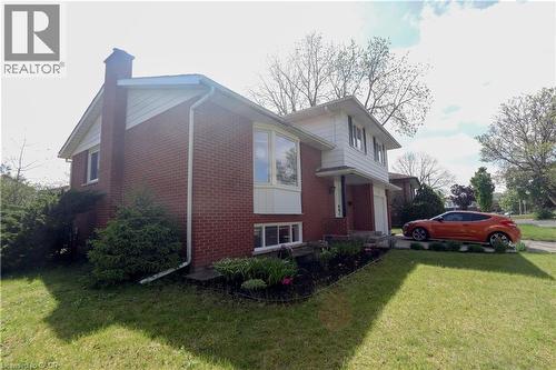 Brick exterior with white siding and a bay window - 77 Orchard Mill Crescent, Kitchener, ON - Outdoor