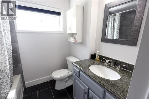 Vanity with stone countertop, undermount sink, and brushed nickel fixtures - 77 Orchard Mill Crescent, Kitchener, ON - Indoor Photo Showing Bathroom