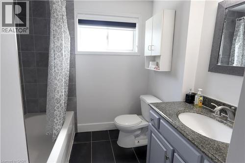 Bathroom featuring a vanity with an integrated sink, granite-style countertop, and grey base cabinetry - 77 Orchard Mill Crescent, Kitchener, ON - Indoor Photo Showing Bathroom