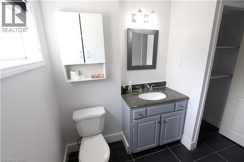 Vanity with a granite countertop, undermount sink, and a framed mirror - 77 Orchard Mill Crescent, Kitchener, ON - Indoor Photo Showing Bathroom