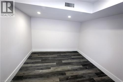 Recessed lighting illuminates the room, featuring wood-finish flooring and white walls - 77 Orchard Mill Crescent, Kitchener, ON - Indoor Photo Showing Other Room
