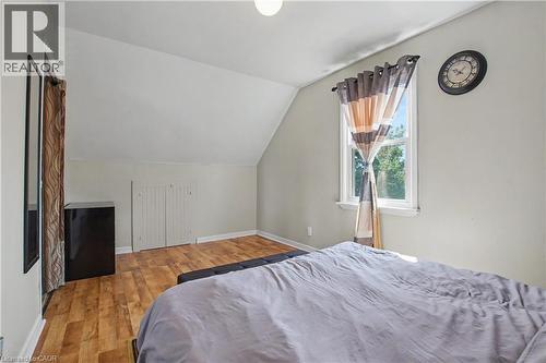 Vaulted ceiling, wood-finish flooring, white window trim, and white bi-fold closet doors - 16 Mercer Road, Cambridge, ON - Indoor Photo Showing Bedroom
