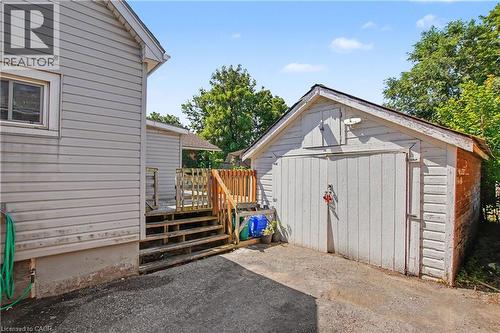 Detached garage with white panel doors, wood-sided exterior, and asphalt shingle roof - 16 Mercer Road, Cambridge, ON - Outdoor With Exterior
