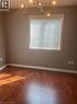 Room featuring wood-finish flooring, a window with blinds, a white window frame, and a modern ceiling light fixture - 4000 Medland Drive, Burlington, ON  - Indoor Photo Showing Other Room 