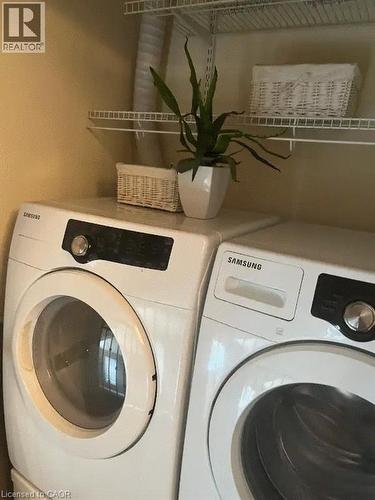Laundry area featuring a side-by-side washer and dryer, white wire shelving, and neutral wall paint - 4000 Medland Drive, Burlington, ON - Indoor Photo Showing Laundry Room