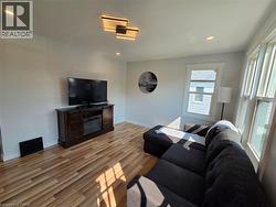 Wood-finish flooring, recessed lighting, and a contemporary ceiling fixture - 