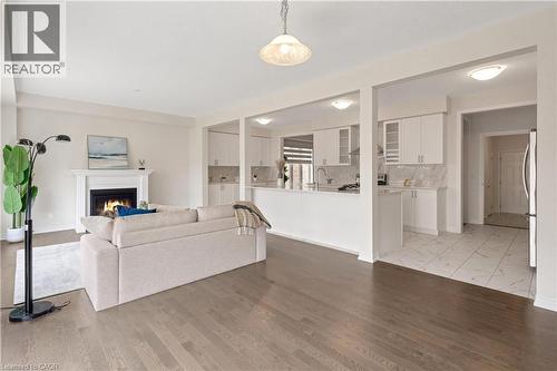 Hardwood flooring throughout, fireplace with a mantle, white cabinetry, integrated kitchen appliances, and tile flooring - 285 Broadacre Drive, Kitchener, ON - Indoor With Fireplace