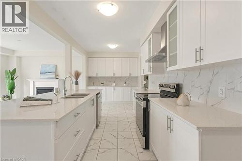 Contemporary kitchen featuring white cabinetry, light-toned countertops, a stainless steel range hood, and a dual-basin sink - 285 Broadacre Drive, Kitchener, ON - Indoor Photo Showing Kitchen With Double Sink