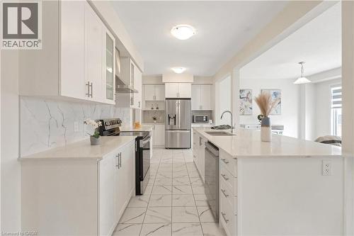 Kitchen with white cabinetry, stainless steel appliances, light-toned countertops, and a tile backsplash - 285 Broadacre Drive, Kitchener, ON - Indoor Photo Showing Kitchen With Double Sink With Upgraded Kitchen
