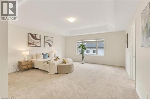 Spacious room featuring a tray ceiling, wall-to-wall carpeting, wide window, and neutral wall color - 285 Broadacre Drive, Kitchener, ON - Indoor