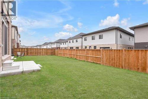 Expansive backyard featuring a lush lawn, privacy fencing, and a concrete patio with steps - 285 Broadacre Drive, Kitchener, ON - Outdoor
