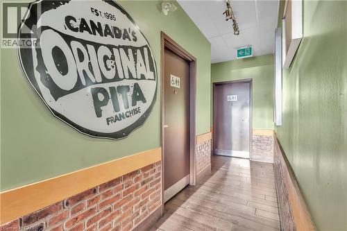 Wood-finish flooring, brick-look wainscoting, light green painted walls, and track lighting - 589 Fairway Road S, Kitchener, ON 