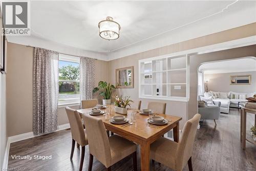 Dining space featuring wood-finish flooring, a window with natural light, a ceiling-mounted light fixture, and a decorative room divider - 481 Upper Gage Avenue, Hamilton, ON - Indoor Photo Showing Dining Room