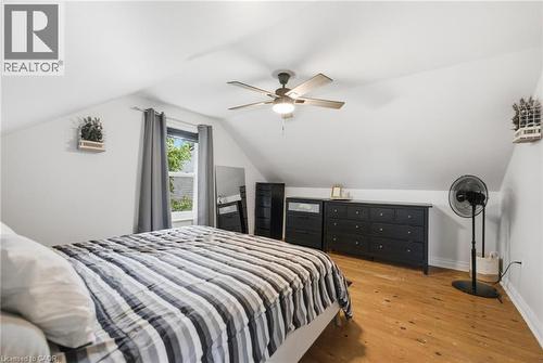 Primary Bedroom featuring hardwood flooring, white painted walls, and a ceiling fan with integrated lighting - 481 Upper Gage Avenue, Hamilton, ON - Indoor Photo Showing Bedroom